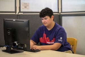 An Upward Bound student sits working at a computer.