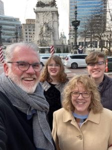Chris Smithhiser and her family stand together in front of Monument Circle in downtown Indianapolis.