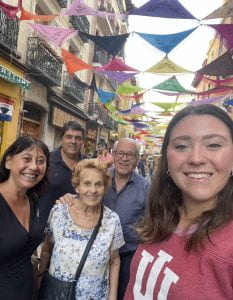 Nerea and her family stand in a street in Madrid below brightly colored banners.