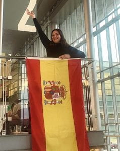 Nerea poses by the Spanish flag hanging in the Campus Center lobby.