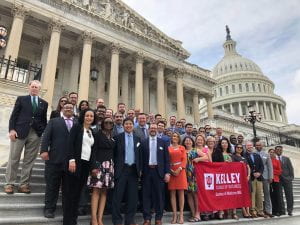 A group of physician MBAs stand on the steps of the U.S. Capitol building in Washington, D.C. holding a Kelley School of Business flag.